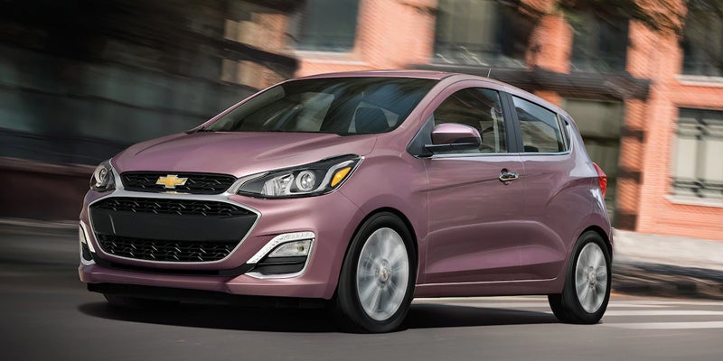 A Chevrolet Spark driving through a city